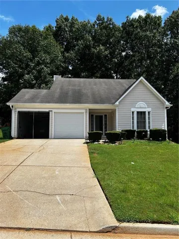Single-story residence featuring light-colored siding, a two-car garage, and a front lawn