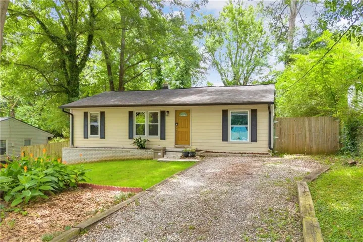 Ranch-style exterior with light-colored siding and dark shutters