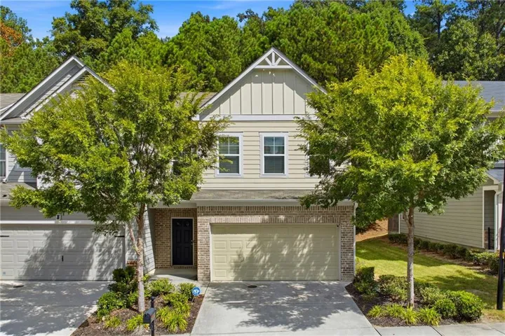 Front elevation featuring a two-story design, a prominent gable, siding, brick accents, and an integrated garage