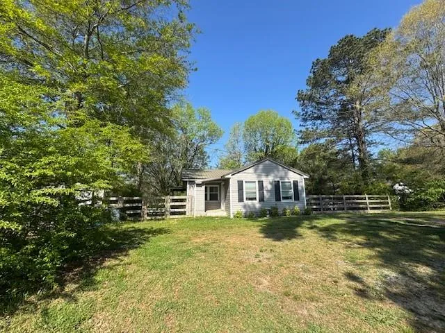 View of front of property featuring a fenced backyard and view of wooded area