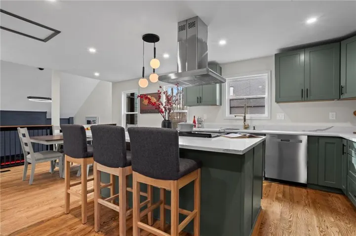 Stone island with seating, modern cabinetry, and stainless-steel dishwasher