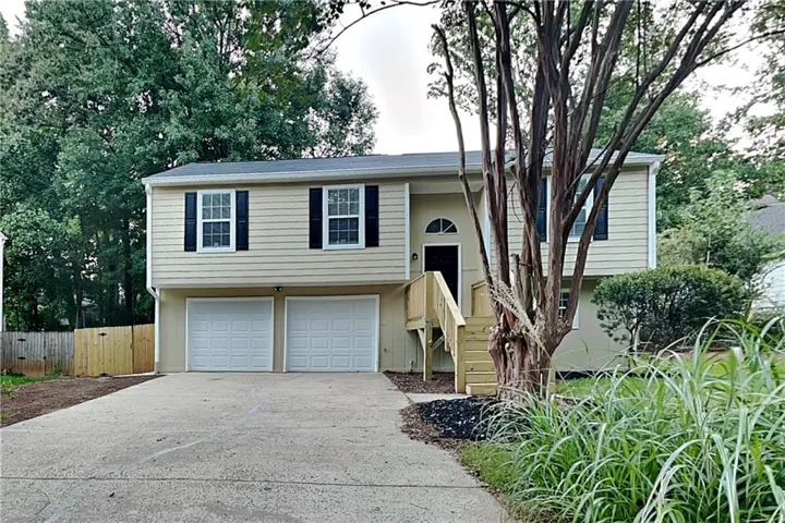 Split-level residence featuring a two-car garage, front entry deck, and arched transom above the door