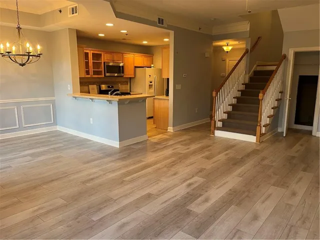 Kitchen with a kitchen breakfast bar, glass fronted cabinets, crown molding, light countertops, and a peninsula