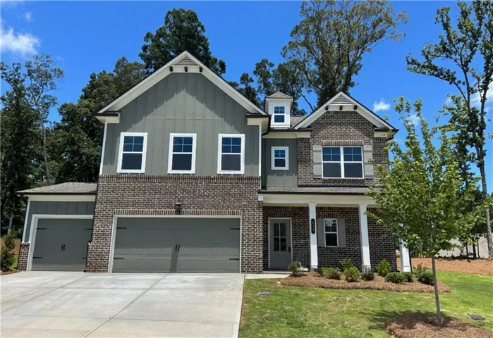 Two-story residence featuring a brick and siding facade with a covered entry