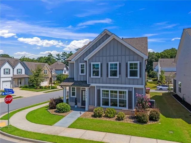 Two-story residence featuring board and batten siding, dark shutters, and a covered porch entry