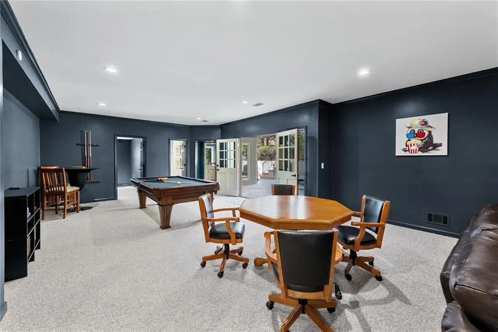 This inviting basement media area features comfortable seating and a built-in fireplace, creating the perfect space for movie nights or relaxing with family and friends. Thoughtfully designed with an open layout, it offers a cozy yet spacious environment for entertainment and leisure.