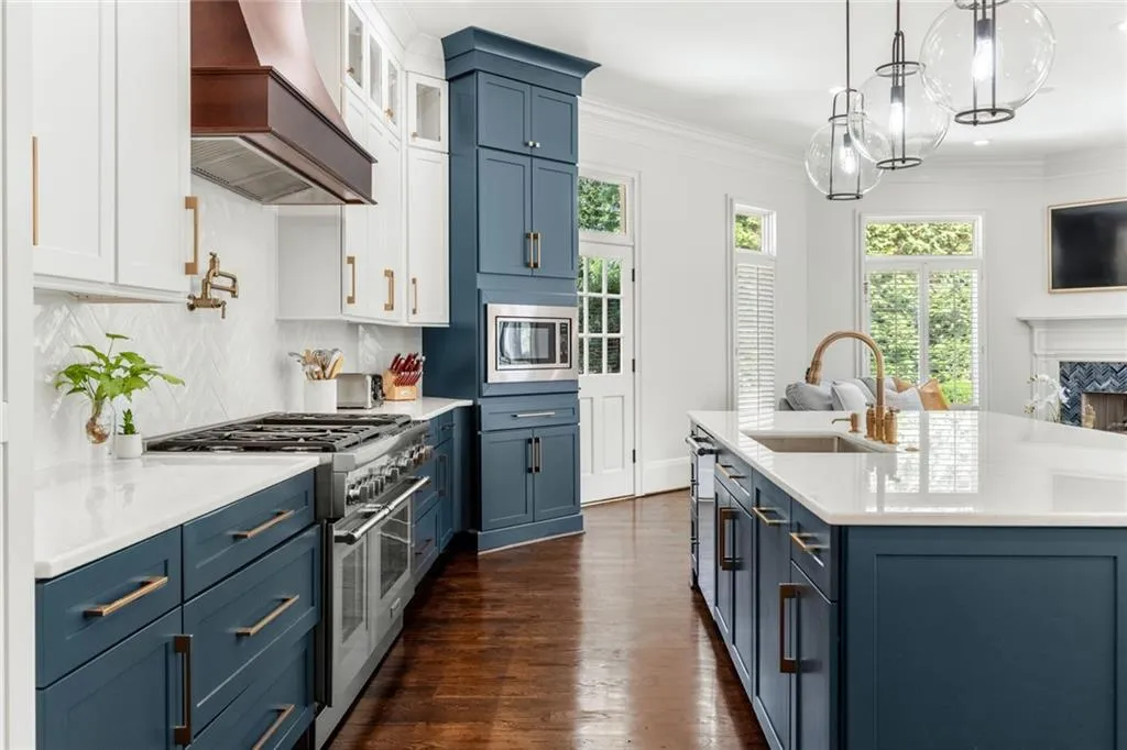 This beautiful kitchen features a seamless connection to the outdoors, with a door leading to a tranquil koi pond setting. Bright and inviting, it blends indoor elegance with serene natural views.