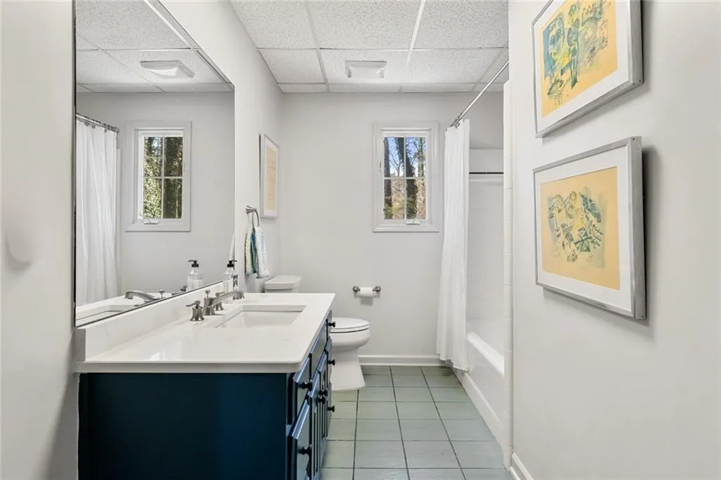 This well-appointed basement full bath features a spacious double vanity, clean modern finishes, and a bright, functional layout.
