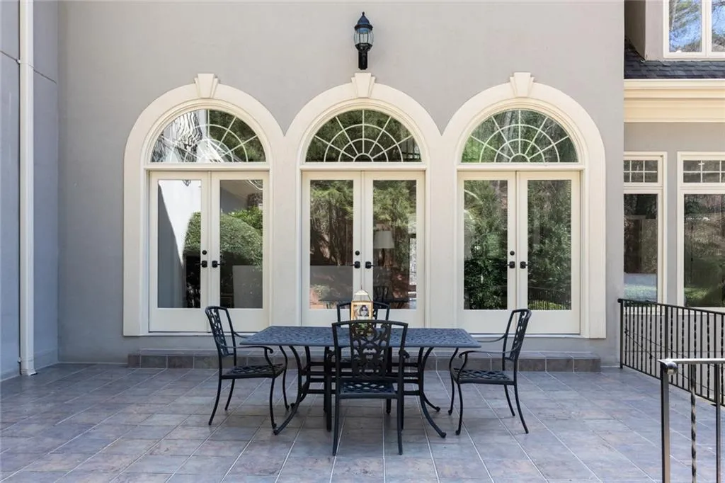 This private patio off the formal living room offers a serene setting with elegant arched openings and beautiful views of the pool and backyard. Perfect for outdoor dining or relaxing, it seamlessly extends the home s living space into a peaceful, resort-like environment.