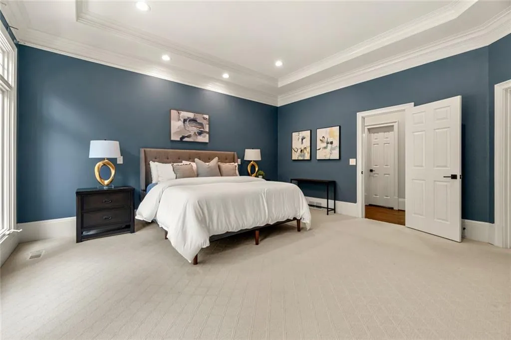 The spacious main-level primary suite offers an expansive layout that easily accommodates a full range of furnishings, providing both comfort and flexibility.
