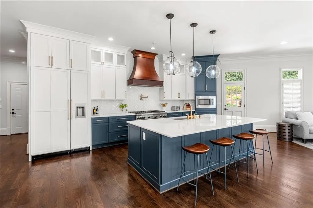 This stunning kitchen features a large marble island, perfect for gathering and meal preparation, complemented by high-end Thermador appliances. A built-in refrigerator and freezer add both style and functionality, completing this beautifully designed space.
