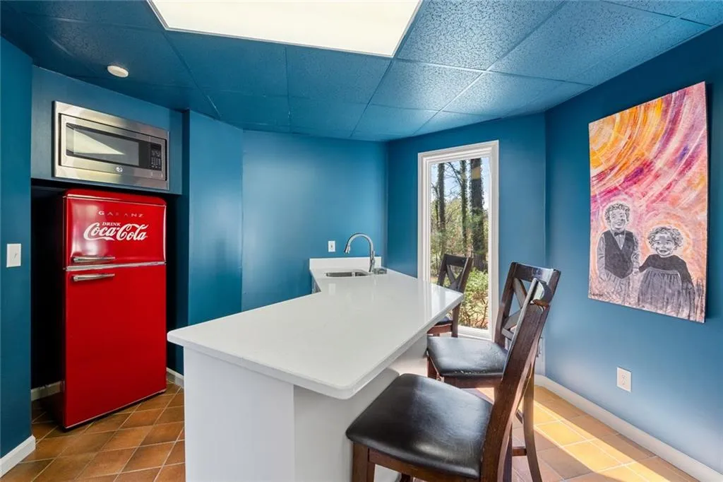This convenient food and beverage area off the pool patio features a serving island, bar seating, and a beverage fridge perfect for effortless outdoor entertaining.