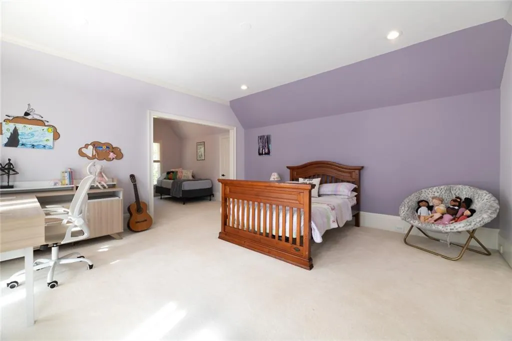 This spacious upper-level secondary bedroom offers plenty of room for sleeping, play, and study, making it ideal for a variety of needs. Large windows with Juliet balconies fill the space with natural light, creating a bright and inviting atmosphere.