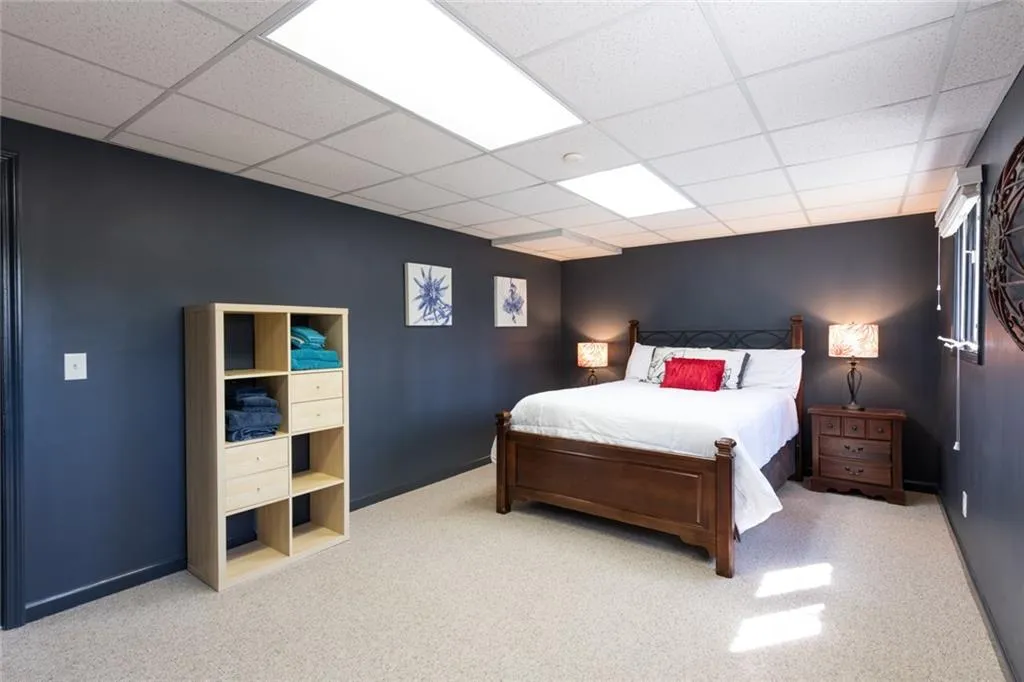 This bright basement bedroom offers plenty of natural light, creating a comfortable and inviting retreat.