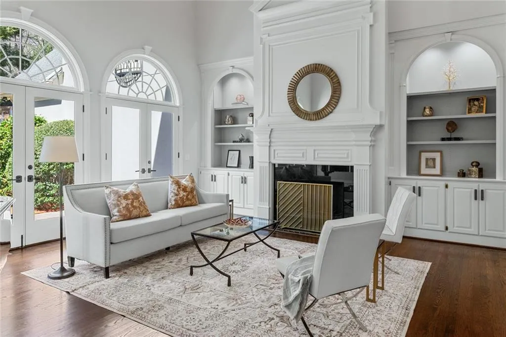 This refined formal living room showcases soaring ceilings, elegant architectural details, and abundant natural light, creating a bright and sophisticated space for entertaining.