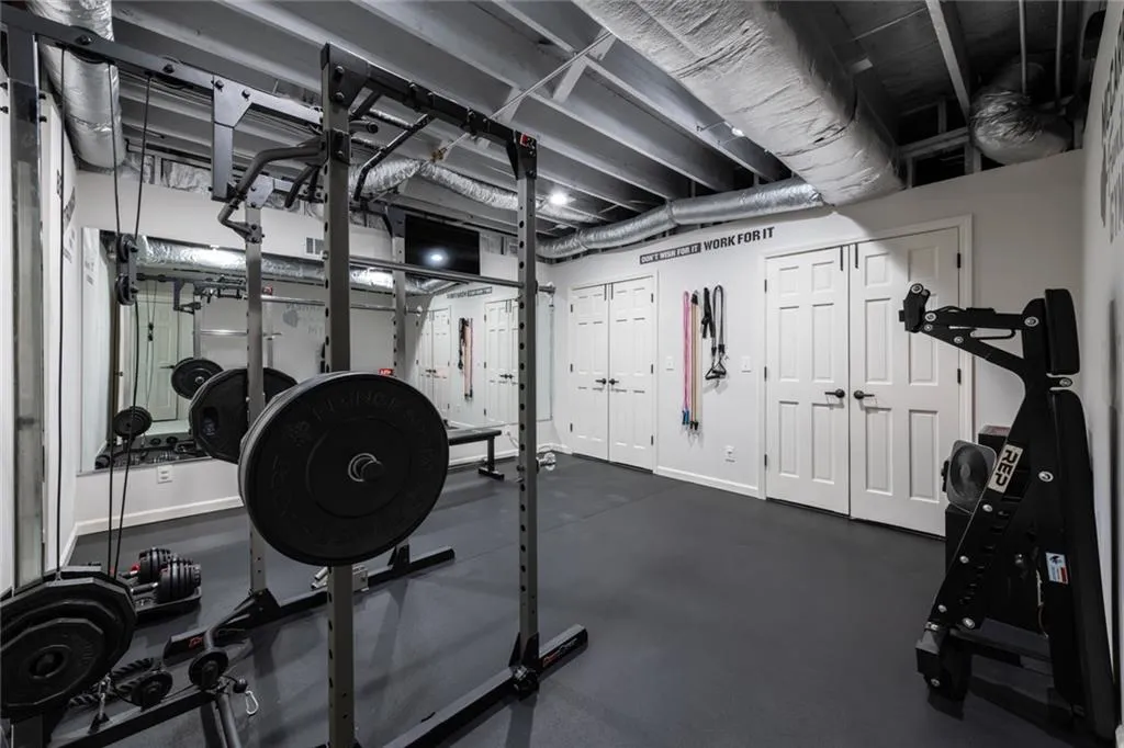 This well-equipped fitness room offers ample space for strength training and workouts, featuring durable flooring and a functional, dedicated exercise setup.