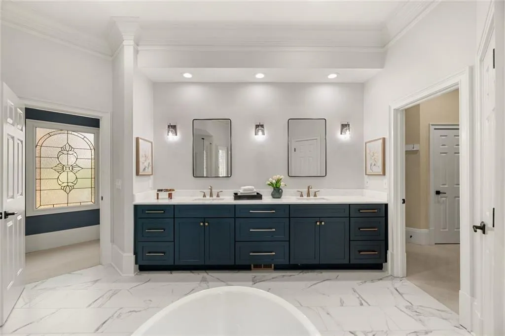 This well-designed primary bath offers seamless flow within the suite, with easy access to a private sitting room and a spacious walk-in closet. Thoughtfully arranged, it enhances both comfort and everyday convenience.
