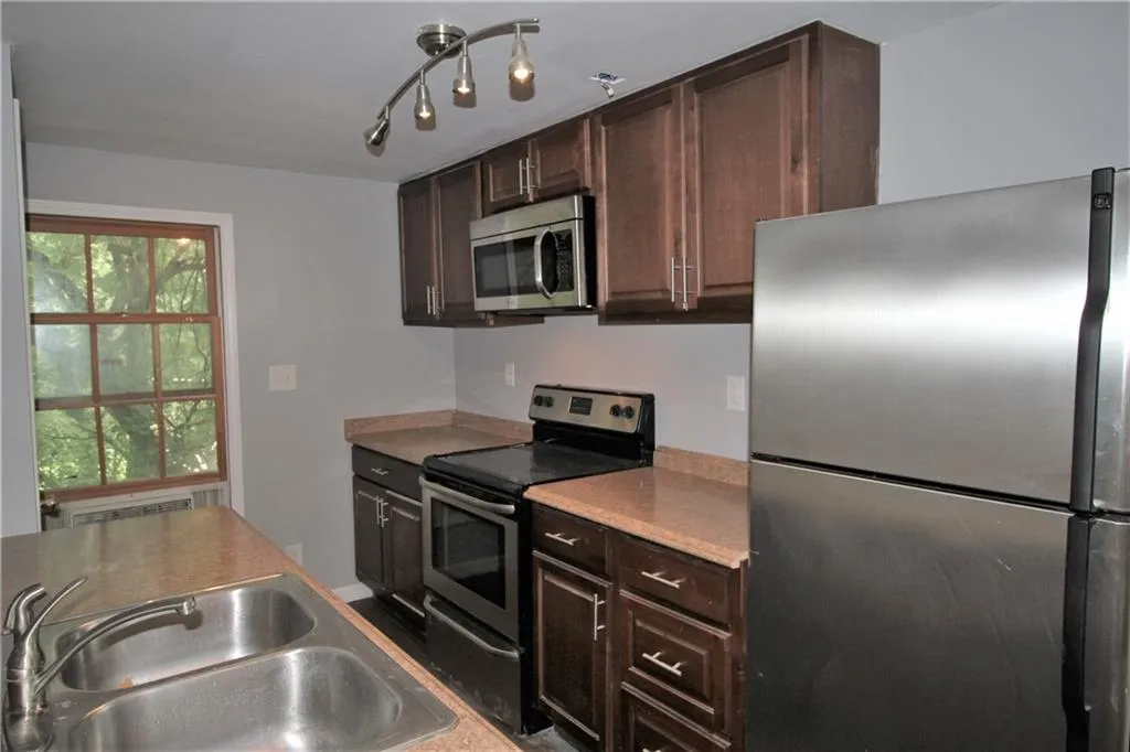 Kitchen featuring dark brown cabinets, a sink, and stainless steel appliances