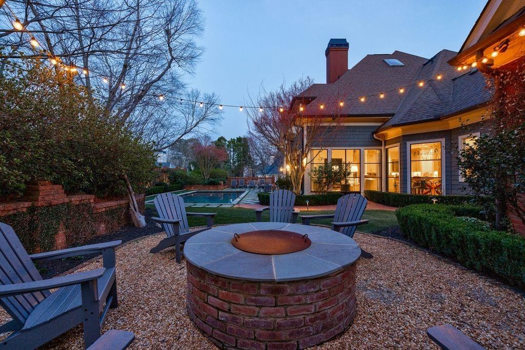 Back yard at dusk with fire pit and swimming pool