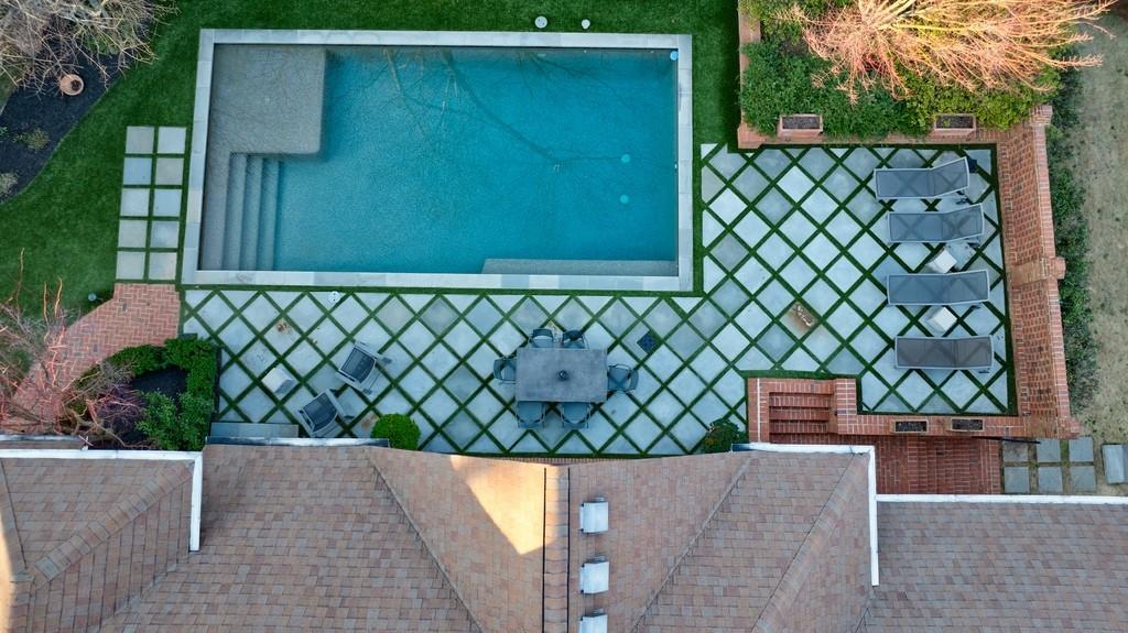 Aerial view of pool with stone patio and turf
