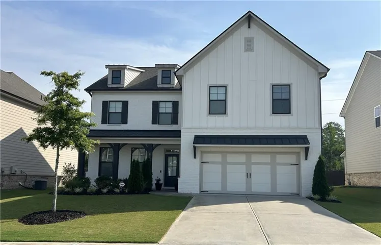 Modern farmhouse exterior featuring white brick and vertical siding