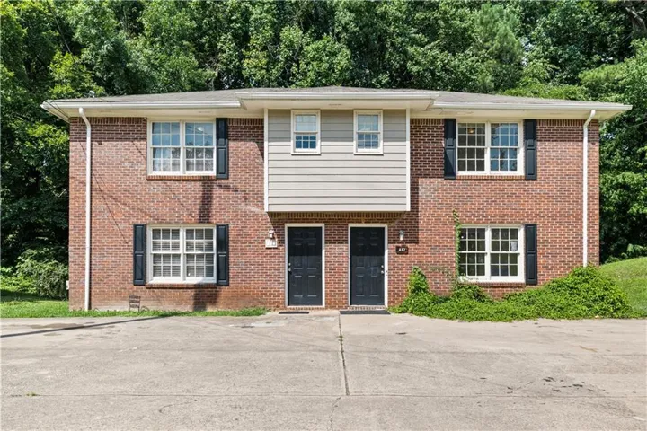 Brick facade duplex featuring a central entry with siding accent