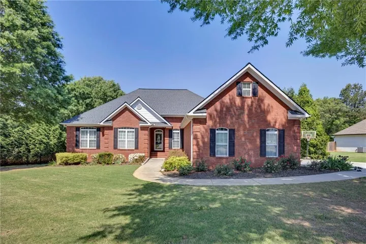 Brick exterior with dark shingle roofing and white trim accents