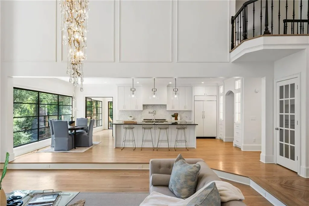 Living room with sink, a towering ceiling, french doors, and a chandelier