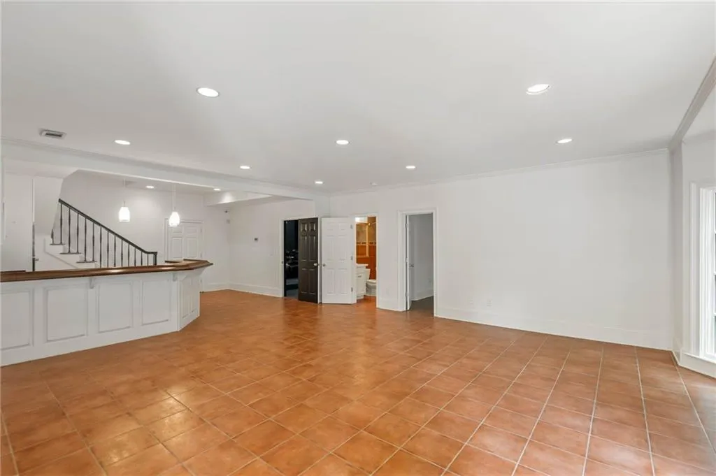 Unfurnished living room featuring light tile patterned floors and crown molding