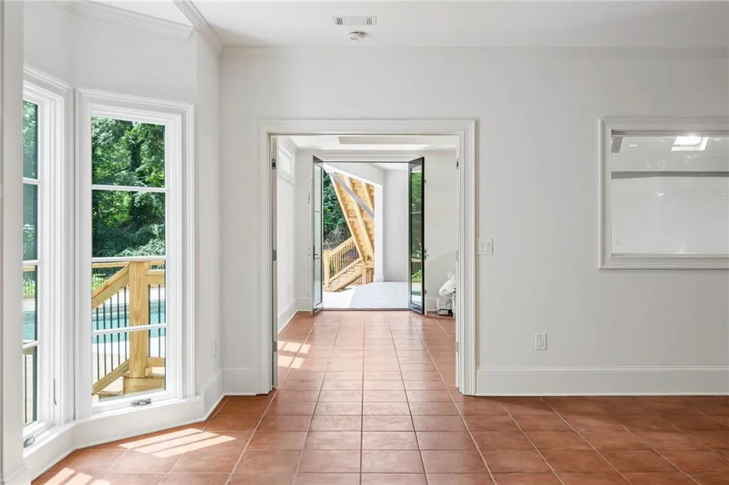 Doorway featuring light tile patterned floors and crown molding