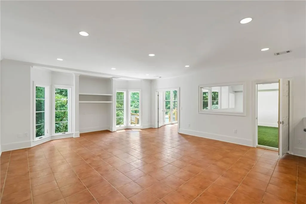 Unfurnished room with light tile patterned flooring and built in shelves