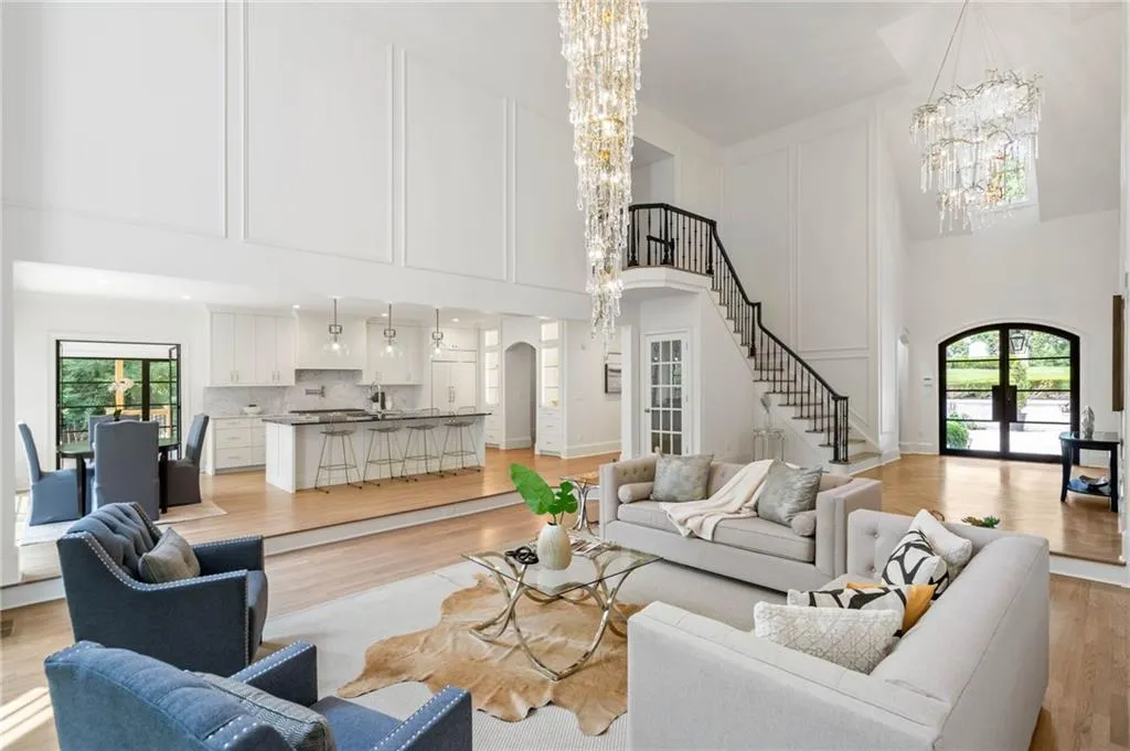 Living room featuring an inviting chandelier, a high ceiling, and light hardwood / wood-style floors