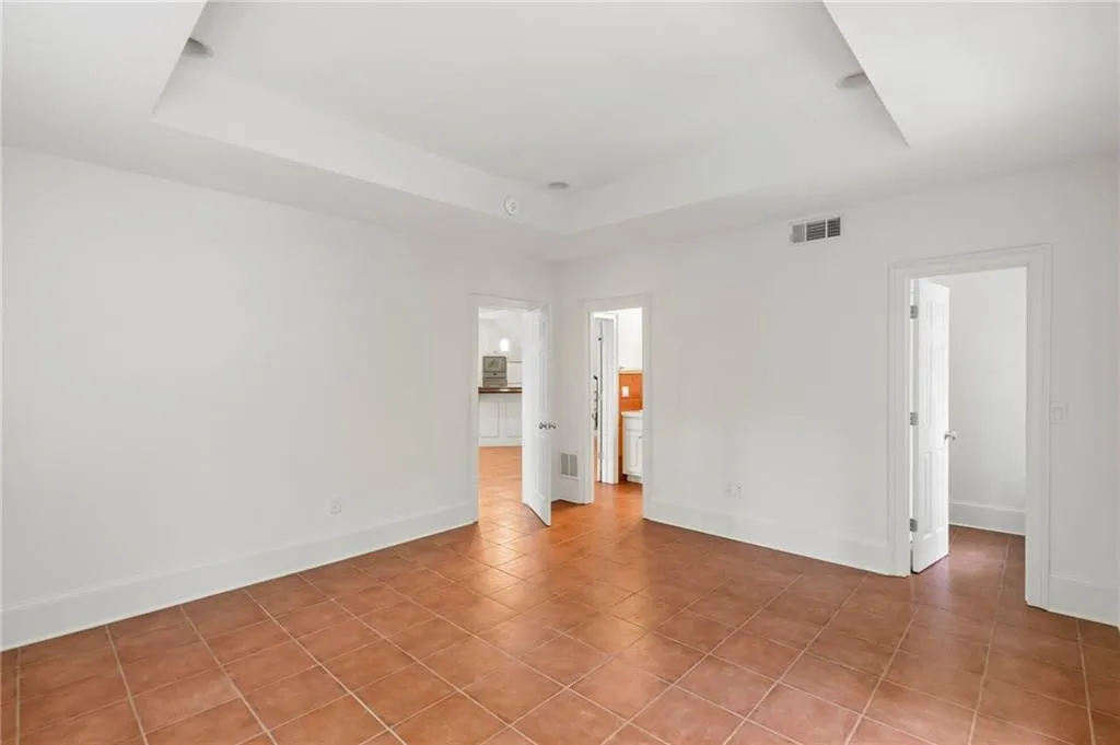 Tiled spare room with a raised ceiling