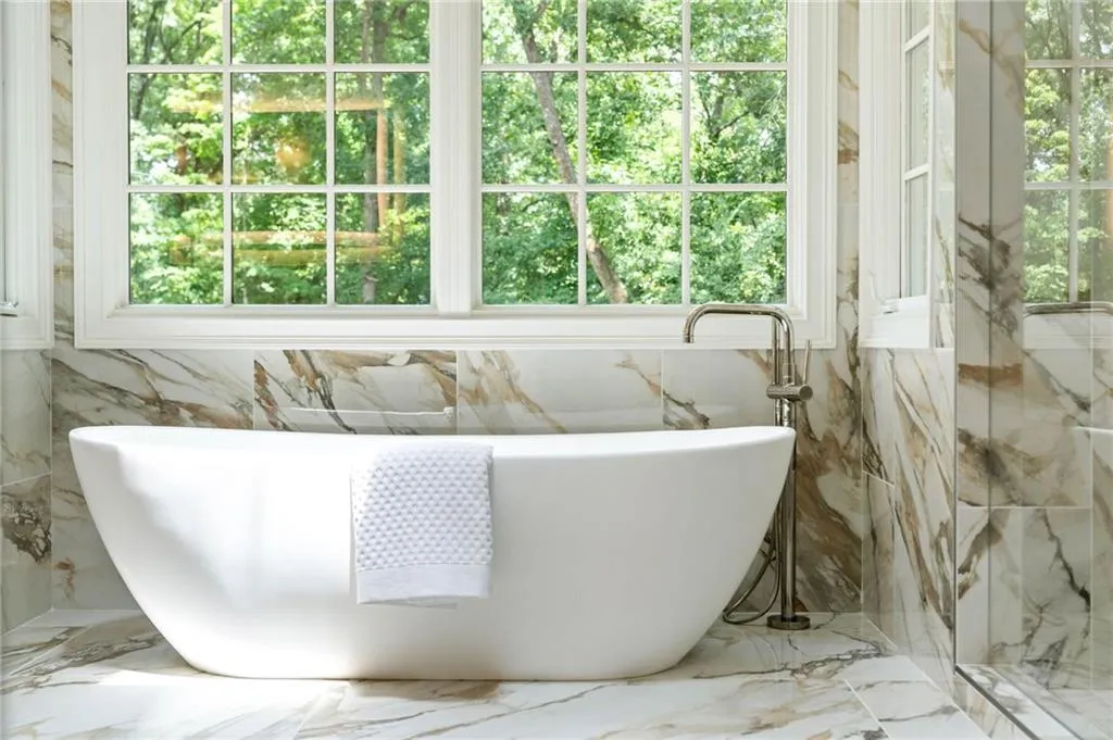 Bathroom with tile walls, a bathtub, and tile patterned flooring