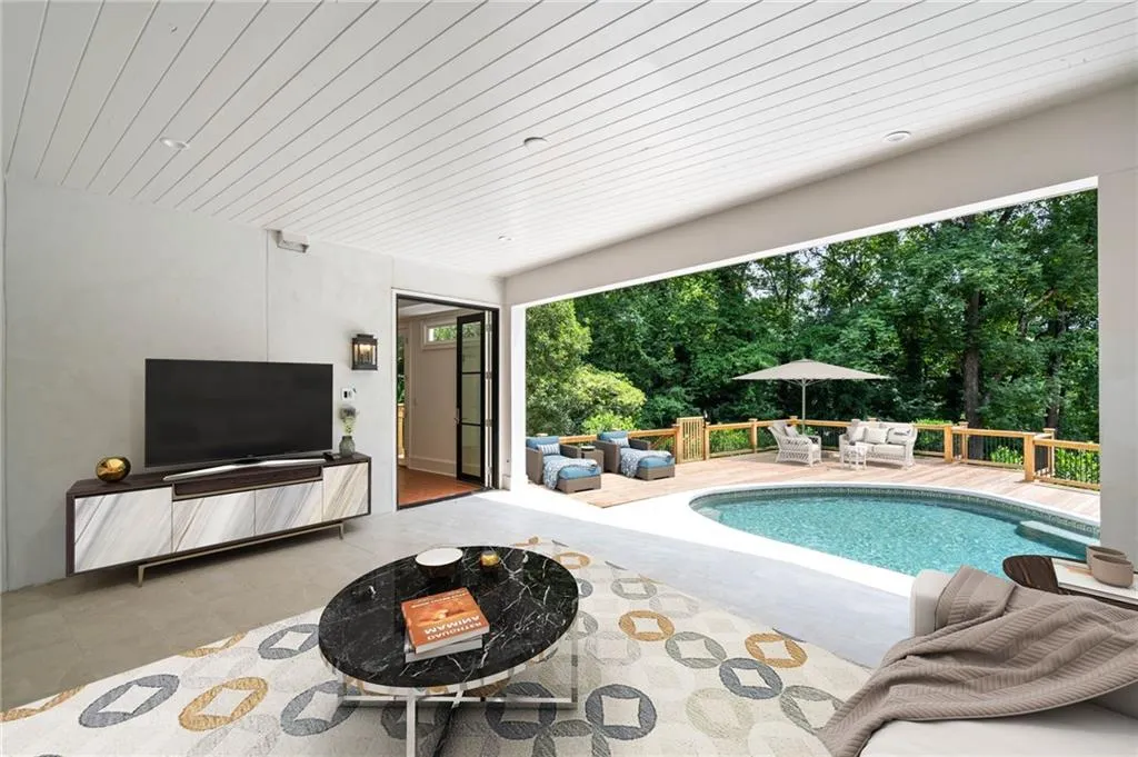 View of swimming pool with a patio and a fire pit