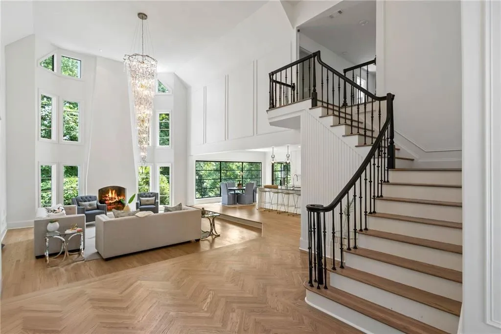 Staircase with plenty of natural light, parquet floors, an inviting chandelier, and a towering ceiling
