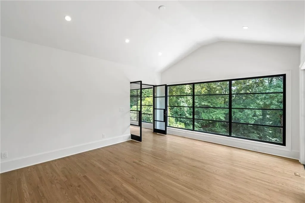 Spare room with light wood-type flooring, vaulted ceiling, and plenty of natural light