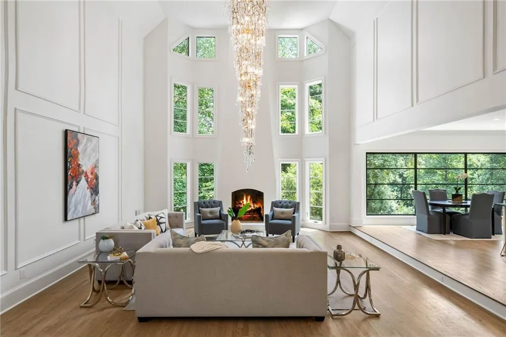 Living room featuring an inviting chandelier, high vaulted ceiling, and light hardwood / wood-style floors