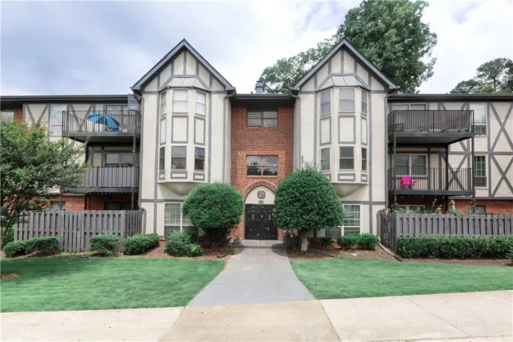 Tudor-style building exterior featuring brick and stucco siding with dark timber accents