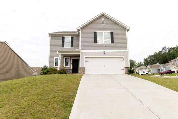 Two-story residence featuring gray siding with white trim, a two-car garage, and a concrete driveway