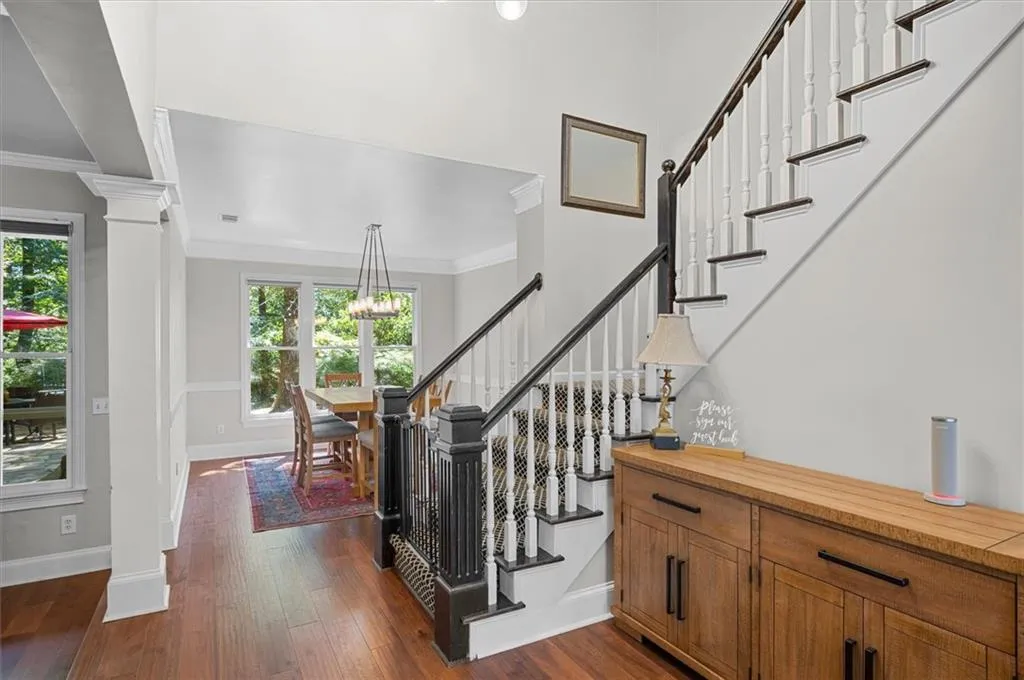Stairs featuring wood finished floors, ornamental molding, ornate columns, views to Dining Room & Private Backyard!