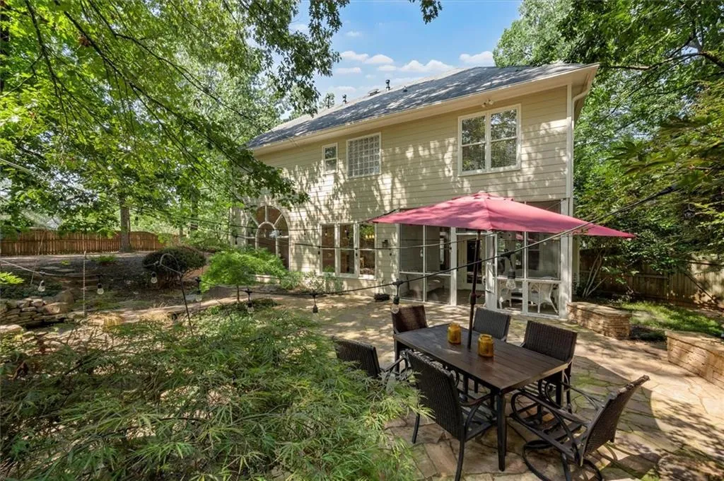 Back of property featuring a  fully fenced backyard, a patio, and outdoor dining area!