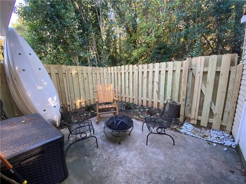 Fenced backyard with a patio area and an outdoor fire pit