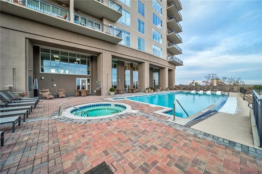 View of swimming pool featuring a patio area and a community hot tub