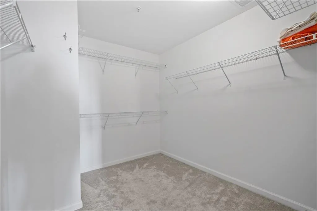 Walk in closet featuring light carpet