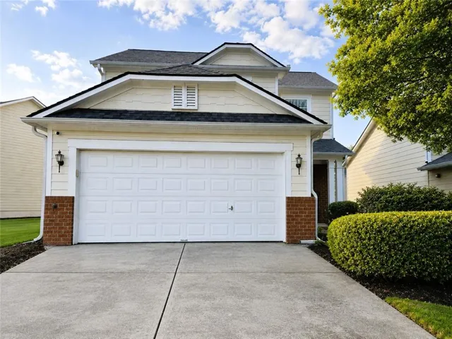 Two-story exterior with light-colored siding and a dark shingle roof