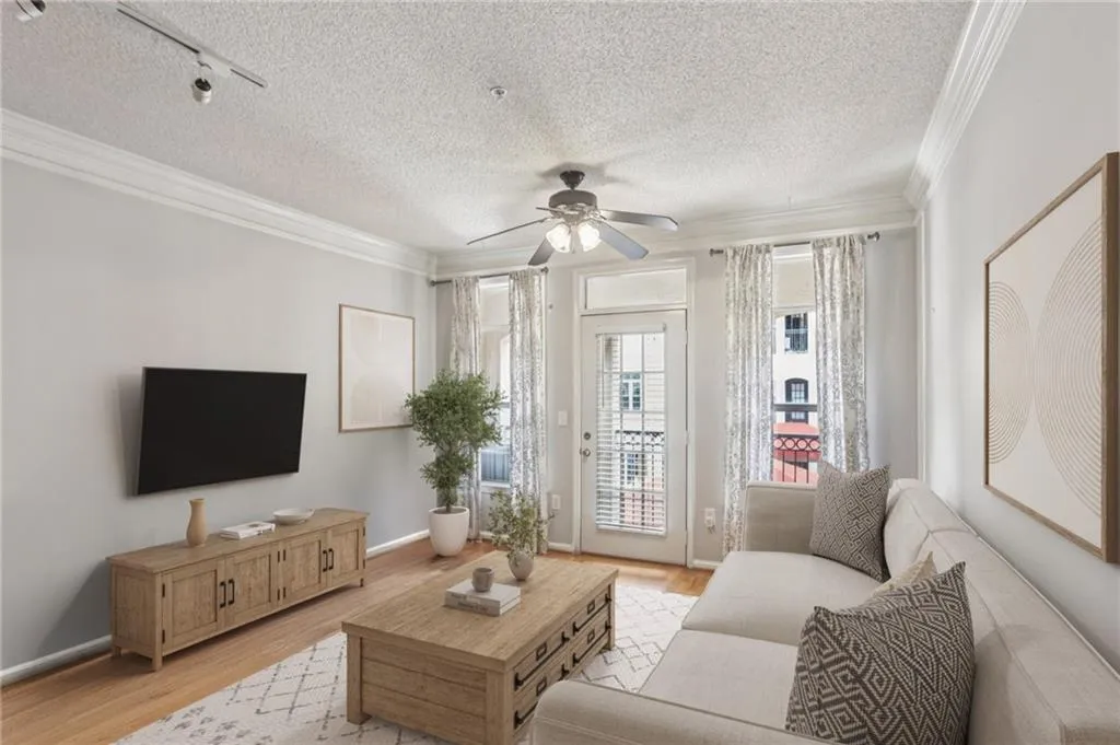 Virtually staged Living room featuring wood finished floors, ornamental molding, a textured ceiling, a ceiling fan, and track lighting