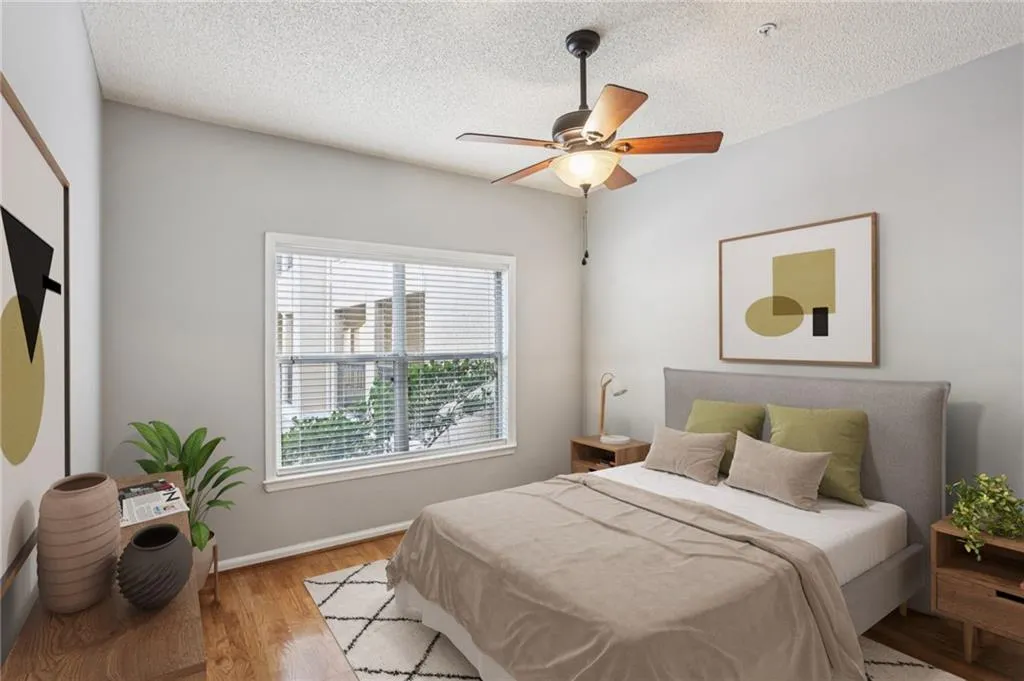 Virtually staged Bedroom with wood finished floors, a ceiling fan, and a textured ceiling