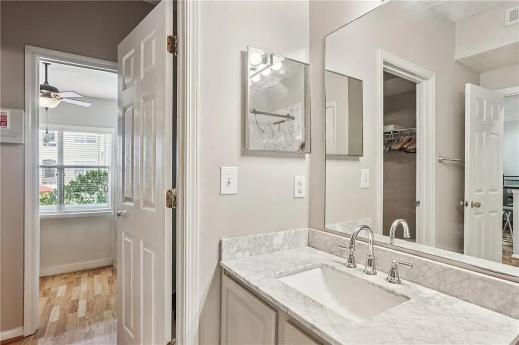 Bathroom with vanity, light wood finished floors, and a ceiling fan