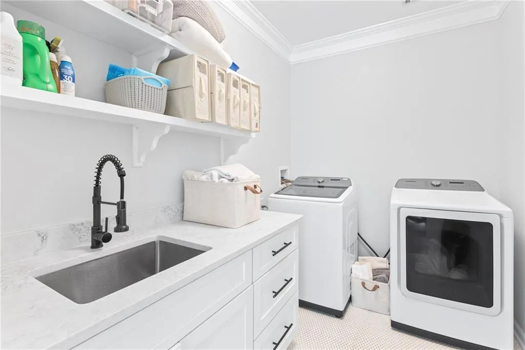 Convenient laundry on bedroom level with cabinetry for storage and sink.